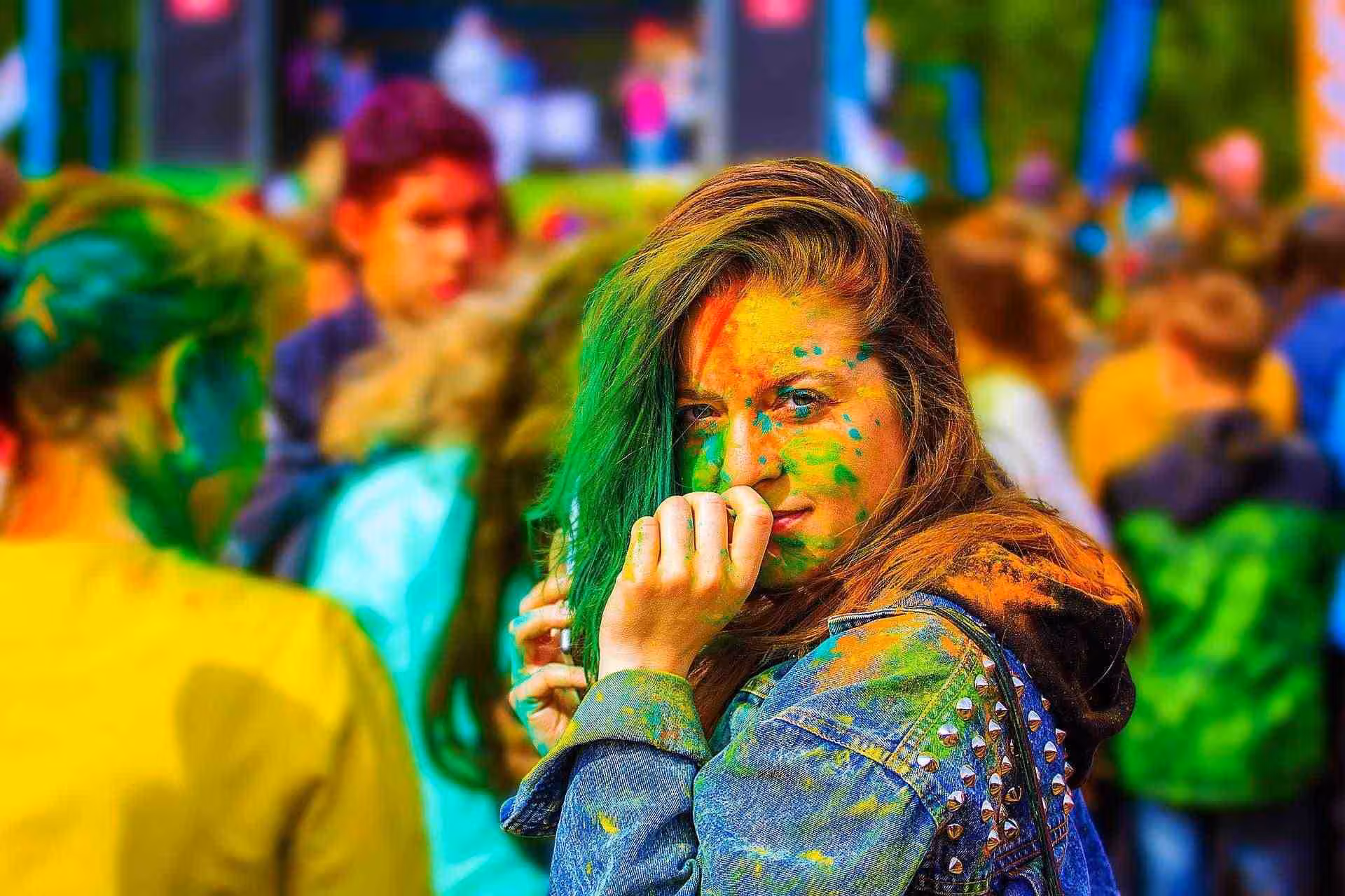 Femme souriante avec le visage couvert de poudres colorées pendant le festival de Holi en Inde